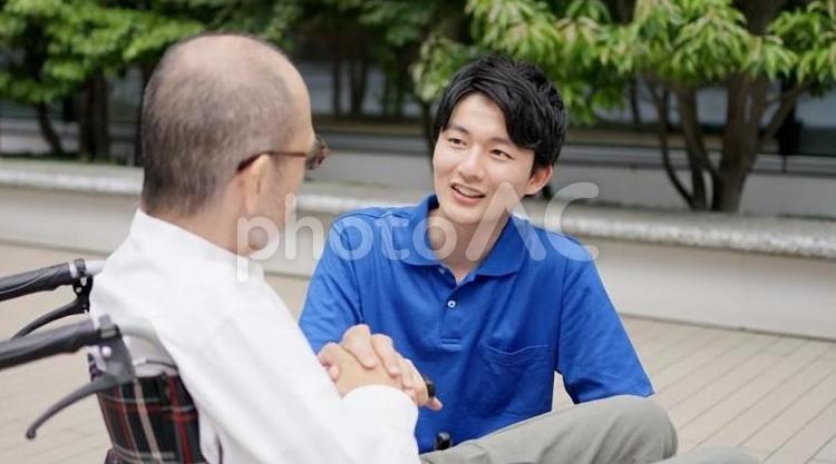 車椅子の高齢者と話をする介護士 高齢者,介護士,話すの写真素材