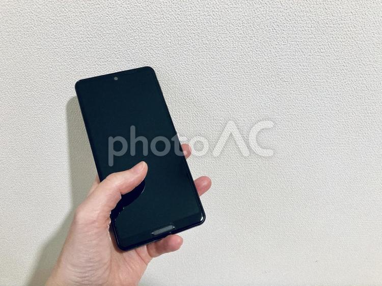 黒いスマホを片手で操作 スマホ,手元,スマートフォンの写真素材
