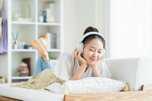 リビングでくつろぐ若い女性 リビングでくつろぐ若い女性 音楽,女性,新生活の写真素材