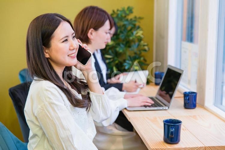 カフェの窓際カウンター席にいる女性（スマホ・笑顔） スマートフォン,スマホ,電話の写真素材