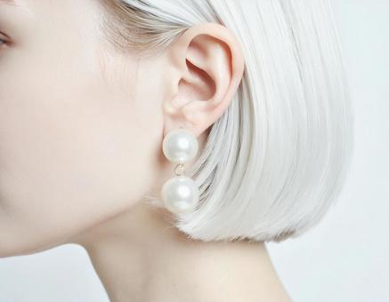 パールのイヤリングをつけた女性の写真