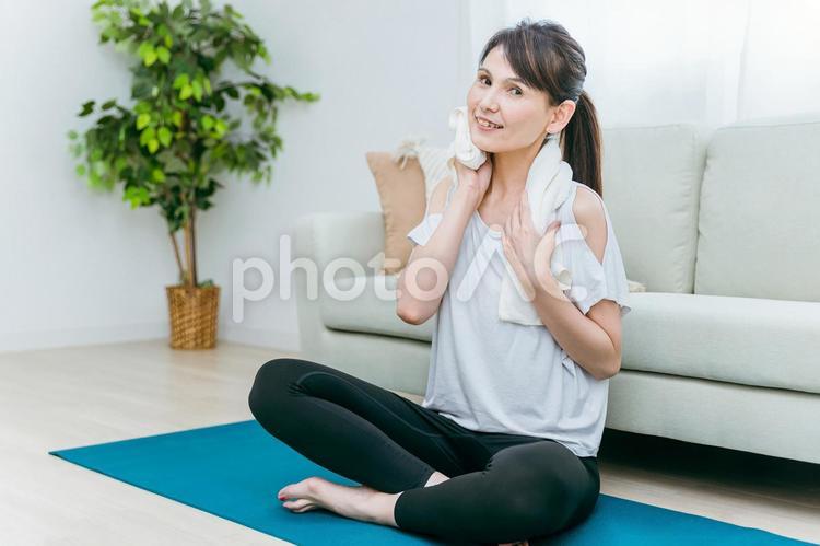 部屋でヨガをする中高年女性（タオル） ホットヨガ,ヨガ,ストレッチの写真素材