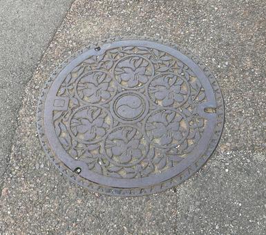 マンホール蓋 群馬県伊勢崎市,ツツジ,勾玉の写真素材