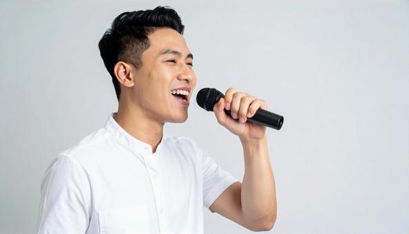 マイクを持って熱唱する日本人男性 マイクを持って熱唱する日本人男性の写真