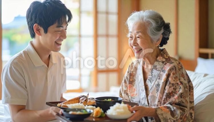 高齢女性と男性介護士の穏やかな食事風景 男性介護士,訪問介護,在宅介護の写真素材