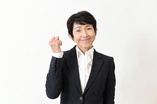 中高年のスーツ姿の女性のガッツポーズ 中高年のスーツ姿の女性のガッツポーズの写真