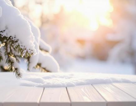雪の中の白い木製テーブルと朝日 雪の中の白い木製テーブルと朝日の写真