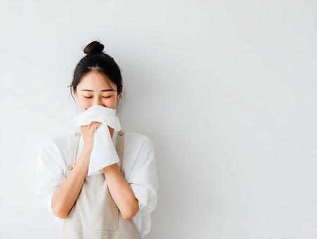 白いタオルを顔に当ててリラックスする女性 白いタオルを顔に当ててリラックスする女性の写真