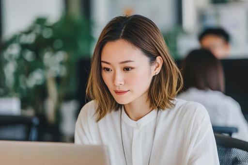 PC画面を真剣に見る女性 PC画面を真剣に見る女性の写真