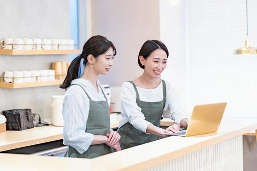 カフェでパソコンを見る店員 飲食店,店員,職場の写真素材
