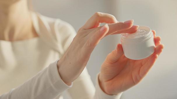 クリームを指に取る女性の上半身 クリームを指に取る女性の上半身の写真