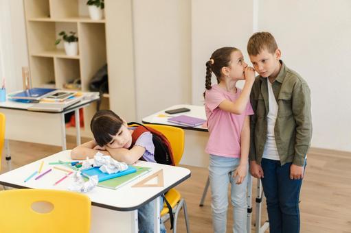 内緒話する生徒と突っ伏す女の子 男の子,女の子,子どもの写真素材