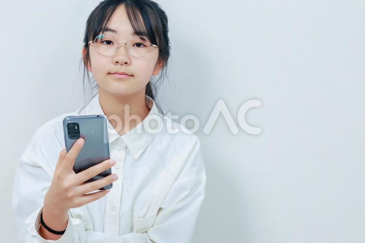 カメラ目線でスマホを持った女の子 女性,小学生,少女の写真素材