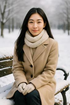 雪のベンチに座る女性の冬景色 雪のベンチに座る女性の冬景色の写真