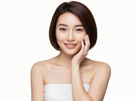 頬に手をあてて微笑むボブカットの若い女性 頬に手をあてて微笑むボブカットの若い女性の写真