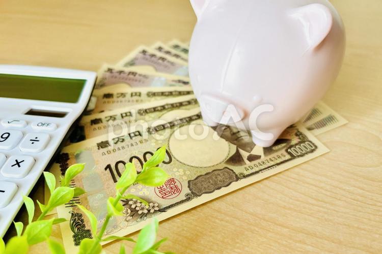 電卓とお金と金色の豚の貯金箱 貯金,やりくり,電卓の写真素材