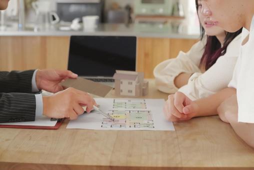 営業マンと家づくりの相談をする若い夫婦 営業マンと家づくりの相談をする若い夫婦 住宅,家,新築の写真素材
