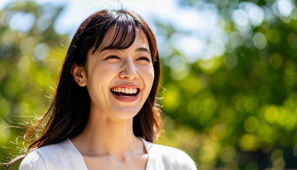 緑豊かな自然の中で笑顔の若い日本人女性 緑豊かな自然の中で笑顔の若い日本人女性の写真