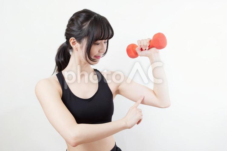 ダンベルを持って二の腕に力を入れる女性 筋トレ,ダンベル,エクササイズの写真素材