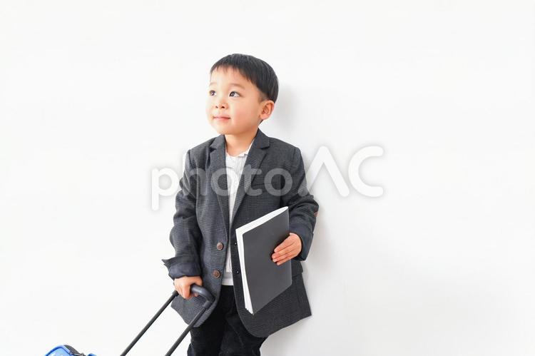 スーツを着て仕事をする子供ビジネスマン 出張,書類,まねの写真素材