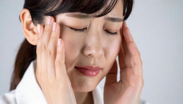 頭痛やストレスに悩む女性のクローズアップの写真