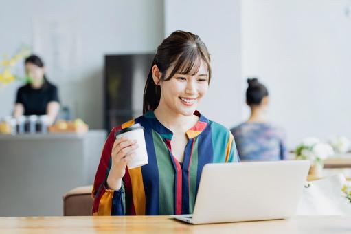 カフェで仕事をするフリーランスの女性 カフェで仕事をするフリーランスの女性の写真