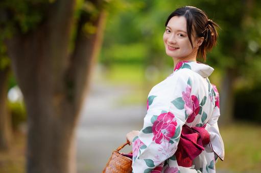 浴衣姿の女性が鞄を持って歩く 女性,浴衣,振り向くの写真素材