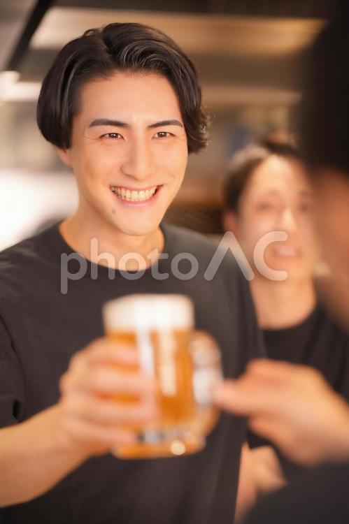笑顔でビールを渡す男性（3人） 男性,大学生,バイトの写真素材