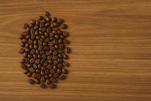 コーヒー豆と木目テーブル コーヒー豆と木目テーブルの写真
