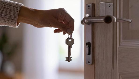 戸締り 玄関の鍵をしめる女性の手 戸締り 玄関の鍵をしめる女性の手の写真