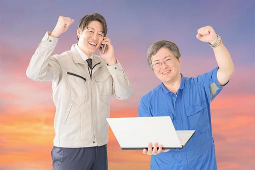 ガッツポーズする作業員と夕日 ガッツポーズする作業員と夕日 開発,ビジネスマン,夕焼けの写真素材