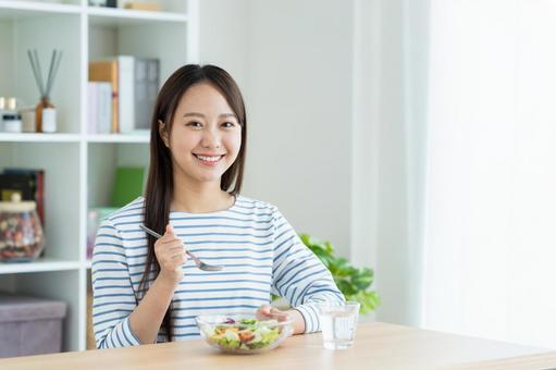 サラダを食べる若い女性 サラダを食べる若い女性の写真