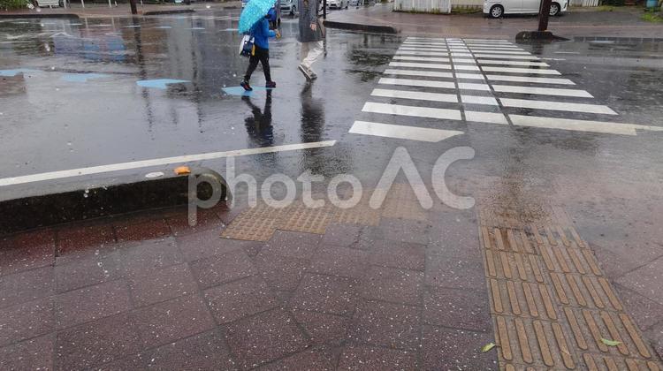 雨の日の交差点と歩く人 雨,交差点,水たまりの写真素材