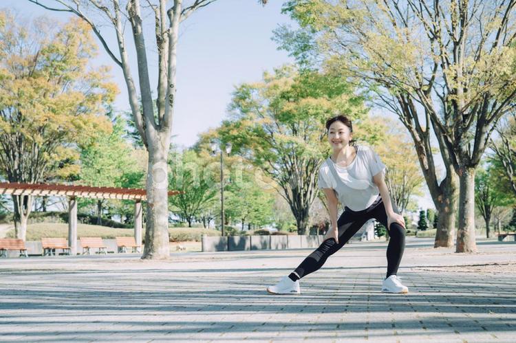 公園で準備運動する女性（屈伸） 準備運動,屈伸,散歩の写真素材