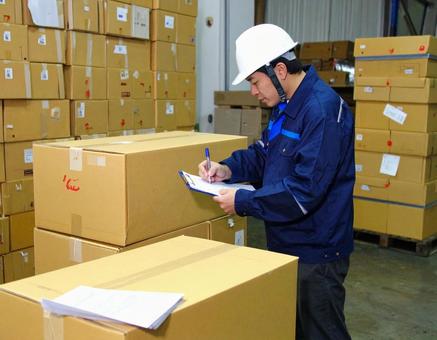 倉庫で在庫をチェックする男性作業員 倉庫で在庫をチェックする男性作業員の写真