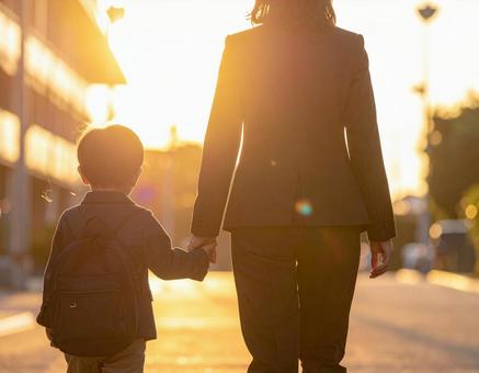 仕事終わり子供の迎えに行った親子の後ろ姿 仕事終わり子供の迎えに行った親子の後ろ姿の写真