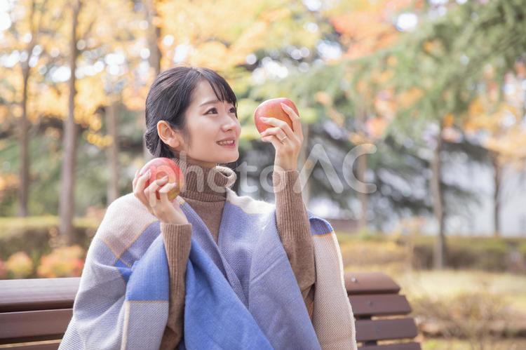 秋の公園でりんごを食べる女性 りんご,秋,女性の写真素材