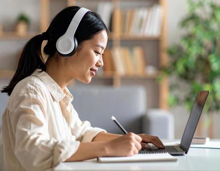 お気に入りの音楽を聴きながら勉強する女性の写真