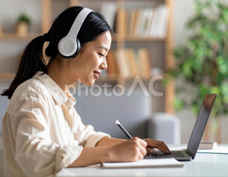お気に入りの音楽を聴きながら勉強する女性 勉強,ノートパソコン,女性の写真素材