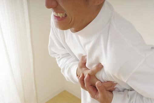 突然の発作に胸を押さえて苦しむ中年男性 心臓発作,狭心症,心不全の写真素材