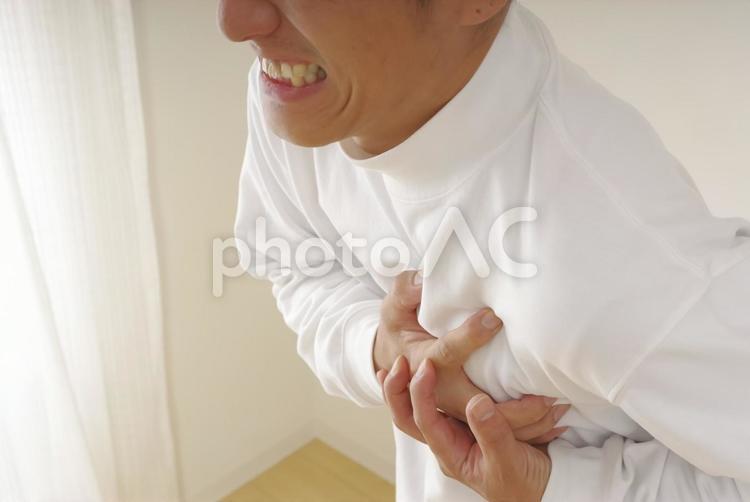 突然の発作に胸を押さえて苦しむ中年男性 心臓発作,狭心症,心不全の写真素材