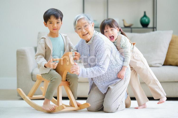 木馬に乗る男の子とひいおばあちゃんにくっつく女の子 おばあちゃん,ひいおばあちゃん,男の子の写真素材