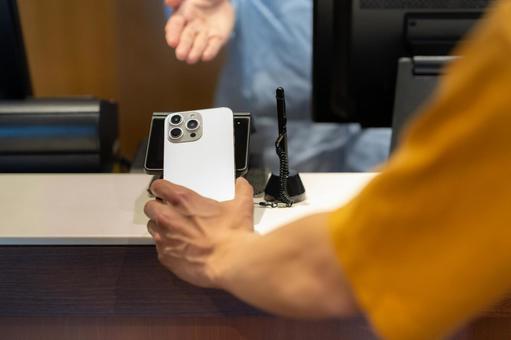 ショッピングをしてモバイル決済をする男性 モバイル決済,ショッピング,買い物の写真素材