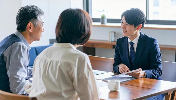 シニア夫婦と営業マン シニア夫婦と営業マンの写真
