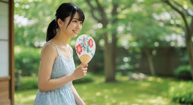 うちわで仰ぐ女性 うちわで仰ぐ女性の写真