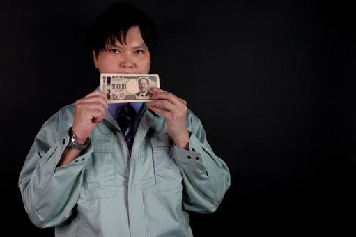 一万円を持つ男性 一万円を持つ男性 男性,一万円札,紙幣の写真素材