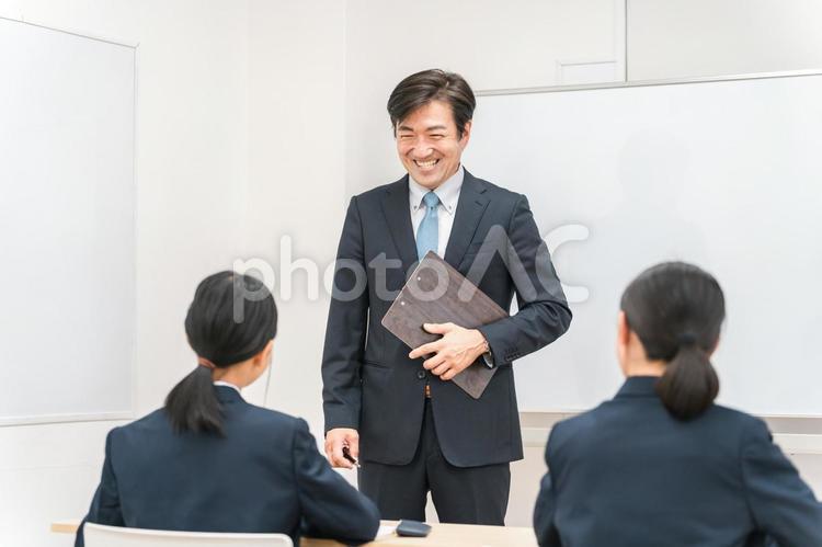 塾・学校の教室で中学生に勉強を教える先生 学校,教室,授業の写真素材