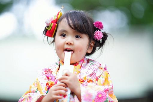 千歳飴を嬉しそうになめる女の子 千歳飴を嬉しそうになめる女の子の写真