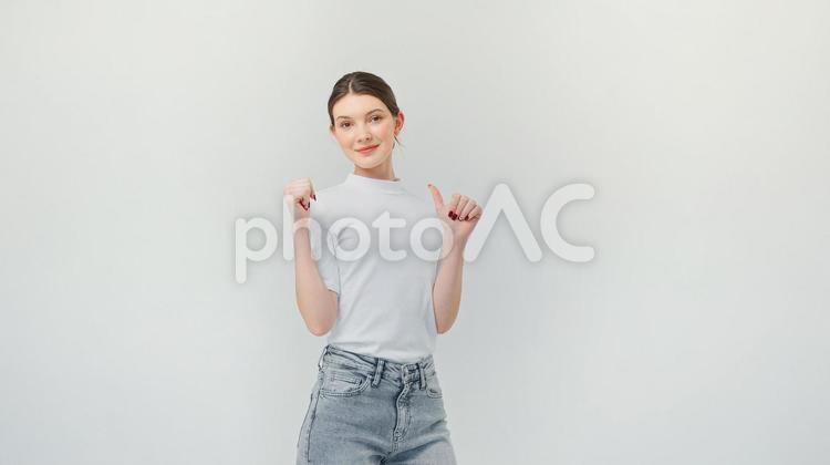 カメラ目線でサムズアップをする女性 女性,指差し,サムズアップの写真素材