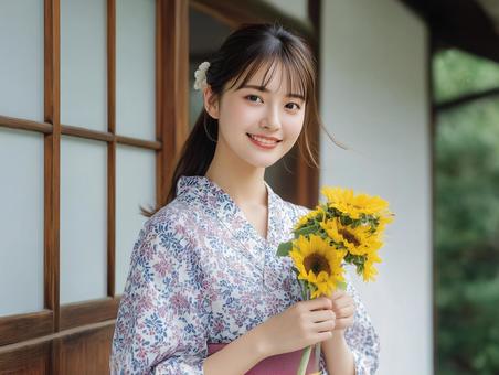 ひまわりを手に持つ浴衣を着た笑顔の女性 ひまわりを手に持つ浴衣を着た笑顔の女性の写真